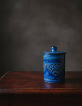 Carregar imagem no visualizador da galeria, Blue ceramic jar with decorative patterns on a wooden surface against a dark background