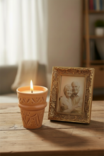 Carregar imagem no visualizador da galeria, Candle in a decorative pot next to a framed photo of an elderly couple on a wooden surface.