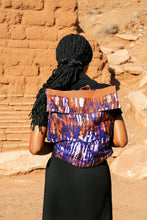 Load image into Gallery viewer, Person wearing a colorful tie-dye backpack against an earthwn background