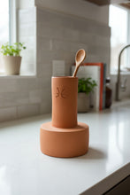 Cargar imagen en el visor de la galería, Terracotta vessel with a cylindrical design, holding a spoon in a kitchen