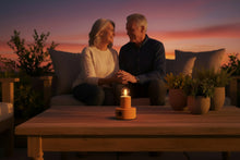 Carregar imagem no visualizador da galeria, ceramic portable lamp on a wooden outdoor table, with an elderly couple sitting on a sofa behind at sunset