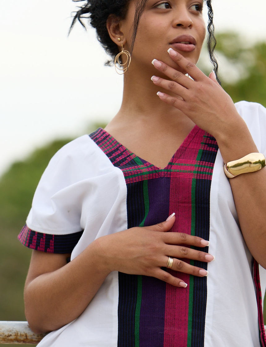Close-up of the Malika Kaftan's black, pink and green handwoven Asooke panel and sleeve trim