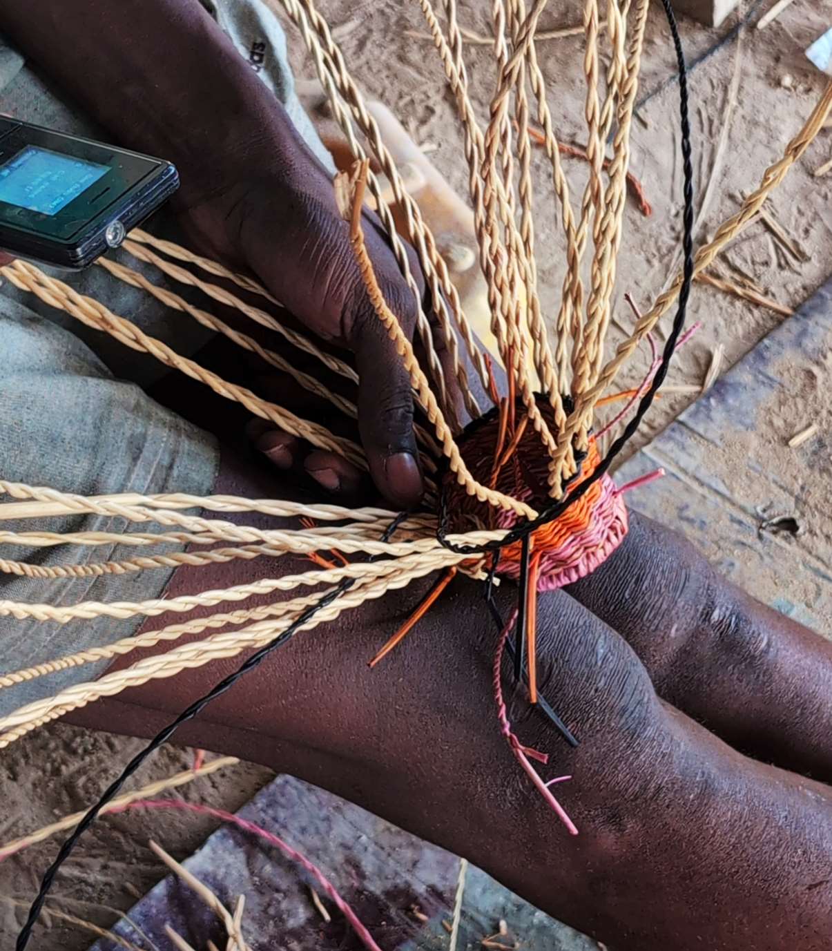 Artisan hands weaving a colourful Etni'KS piece