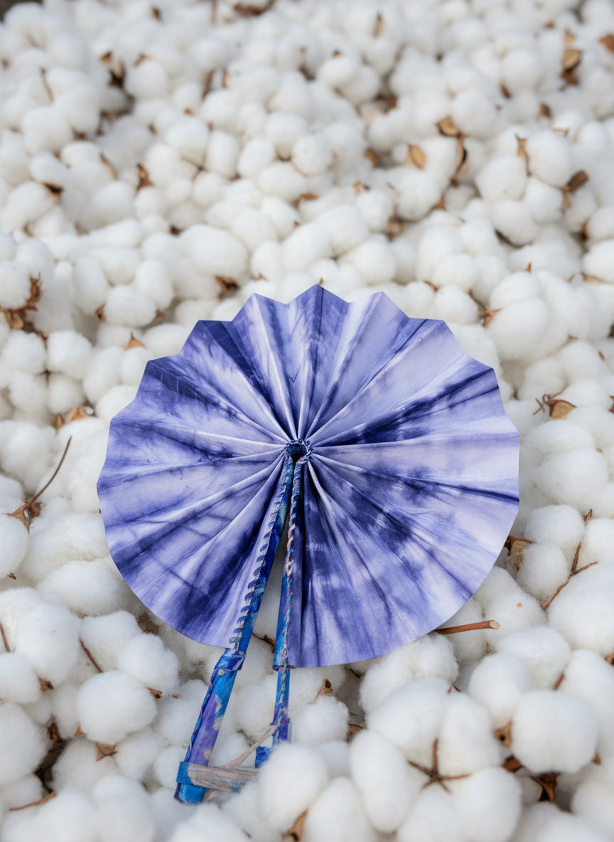 Blue tie-dye fan laying on a pile of cotton buds harvest 
