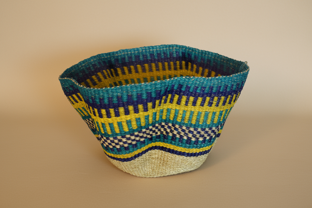 A handwoven basket featuring geometric patterns with blue, yellow, and natural tones