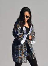 Carregar imagem no visualizador da galeria, Woman wearing an African patterned cardigan against a gray background

