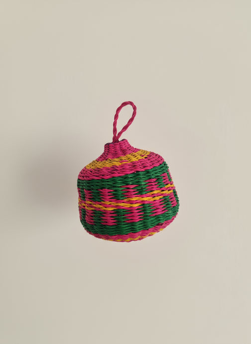 Colorful woven ball with a pink handle on a beige background