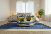 Cargar imagen en el visor de la galería, Cat sitting in a colorful woven pet bed in a bedroom.
