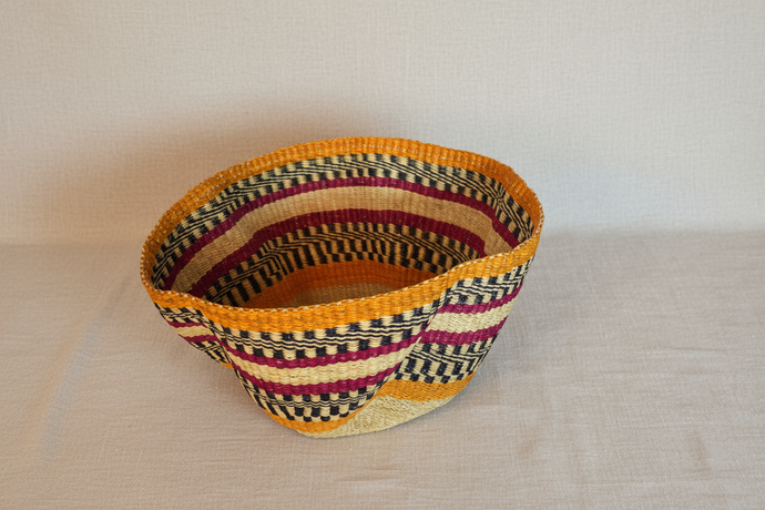 Woven basket with multicolored pattern on a beige background