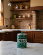 Carregar imagem no visualizador da galeria, Green ceramic jar with decorative patterns on a marble countertop in a kitchen.
